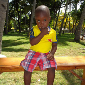 A young boy sitting on a Jean Josue Caceus.