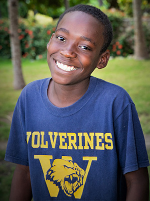 A boy wearing a Sander Louis t - shirt.