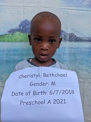 A boy holding up a sign that says christopher bethshol gender m.