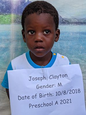 A young boy holding a sign that says joseph clayton.