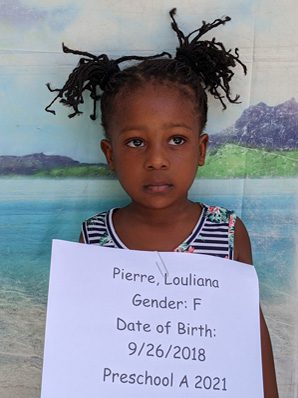 A little girl holding up a sign with the date of birth.