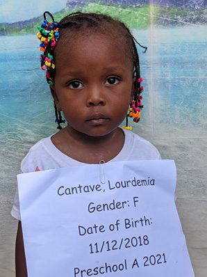 A little girl holding up a sign that says gender f.