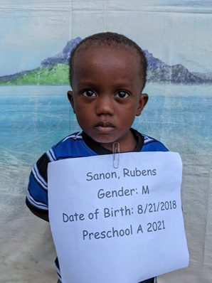 A young boy holding up a sign that says samantha rubins.