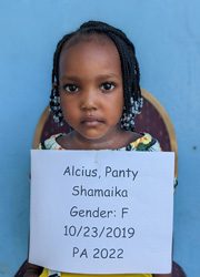 A little girl holding up a sign that says alicia party shamaka gender f.