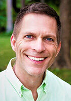 A smiling man in a green shirt.